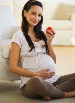 Pregnant woman eating an apple